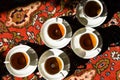 Vintage soviet porcelain cups of tea with saucers on turkish carpet, traditional tea ceremony, sunlight Royalty Free Stock Photo