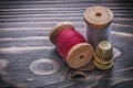 Vintage spools of thread thimbles on wooden board handicraft con