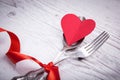 Vintage spoon and fork with a red tape and heart for Valentine`s day on a wooden Royalty Free Stock Photo