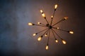 A vintage sputnik black decorative chandelier hanging from a dark ceiling in a room