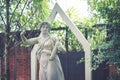 Vintage statue. A portrait shot of vintage statue in the garden. Classic lady in Roman style playing small harp, string musical