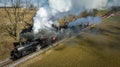 Vintage steam locomotive engine is pictured traveling through a lush green countryside