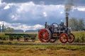 A vintage steam tractor pulling a green waggon on a dusty farm road at Sandstone Estates, South Africa. Royalty Free Stock Photo