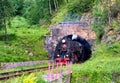 Vintage steam train leaves from arch of railroad tunnel