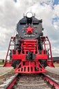 Vintage steam train on the rails close-up on blue sky background, retro vehicle, steam engine