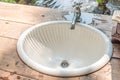 Vintage steel faucet and antique ceramic wash basin sink on old wooden counter bathroom interior for home and living architecture Royalty Free Stock Photo