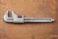 Vintage steel wrench on a rusty background