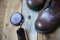 Vintage still life with aged brown boots, shoe polish and shoe brush