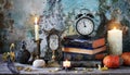 Vintage still life with antique books, clock and candle. Halloween and occult concept