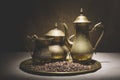 Vintage still life with heap of coffee beans near old copper coffeepots on bronze tray against canvas background