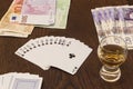 Vintage still life of playing cards, cash money and shot of alc