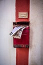 Vintage Italian Charm: Old White Wall with Red Stripe, Red Mailbox, and Mail Sticking Out in Typical Polignano a Mare Street Royalty Free Stock Photo