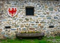 Vintage stone wall with little window, coat of arms of Alto Adige, Italy