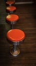 Vintage stools in the restaurant. Row vintage stools in front of wooden counter inside a vintage style bar Royalty Free Stock Photo