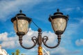 Vintage street forged black double lantern with patterns on a blue sky background close-up Royalty Free Stock Photo