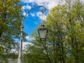 Vintage street lamp against a background of blossoming tree and blue sky Royalty Free Stock Photo