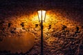 Vintage street lamp against a brick wall at night Royalty Free Stock Photo