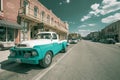 Vintage Studebaker pick-up truck parked in street beside traditional architectural buildings in infrared filmic style