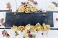 A blank slate sign with dried roses and hydrangea petals