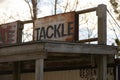 Vintage-style building features a distressed sign that reads 'Tackle' above its door