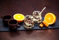 Vintage style ceramic cups, fresh orange, tiramisu dessert in glass jars and chocolate candies