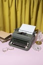 Vintage style concept with typewriter, glasses, books and crystal glass on yellow curtain background Royalty Free Stock Photo