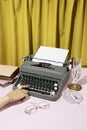 Vintage style concept with typewriter, glasses, books, wooden hand and crystal glass on yellow curtain background Royalty Free Stock Photo