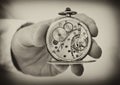 Hand holding antique pocket watch show the clockwork mechanism. Royalty Free Stock Photo