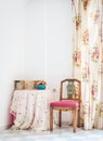 Vintage style interior with table, carved chair and floral curtain Royalty Free Stock Photo