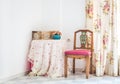 Vintage style interior with table, carved chair and floral curtain Royalty Free Stock Photo