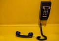 Vintage style black phone display on yellow wall Royalty Free Stock Photo