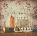 Vintage style photo of old pearl necklace and perfume over floral pattern background. retro filtered image