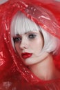 Beautiful woman with platinum blonde hair wearing red plastic raincoat Royalty Free Stock Photo