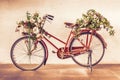 Vintage style of red bicycle with flower baskets parking against Royalty Free Stock Photo