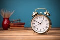 Vintage style retro alarm clock rests beside blank note paper on a wooden table Royalty Free Stock Photo