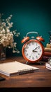 Vintage style retro alarm clock rests beside blank note paper on a wooden table Royalty Free Stock Photo