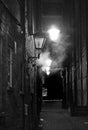 Vintage style sepia view of an old dark narrow city alley with lamplight and fog known as turks head yard in briggate leeds Royalty Free Stock Photo