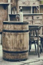 Vintage stylized photo of wooden barrel with bottles of wine