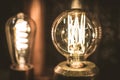 Vintage stylized round tungsten lamp glowing in dark, close-up photo with selective focus and shallow DOF Royalty Free Stock Photo