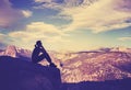 Vintage stylized silhouette of a woman watching mountain view.