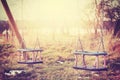 Vintage stylized two neglected empty swings.