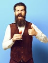 Vintage suede leather waistcoat on blue studio background, funny handsome bearded man Royalty Free Stock Photo