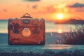 Vintage suitcase against sunset or dawn background, travel concept Royalty Free Stock Photo