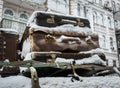 Vintage suitcases covered with snow on the roof of a car against the background of an old house Royalty Free Stock Photo