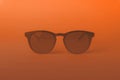 Vintage sunglasses in orange lighting. Pink suglasses in minimal and summer concept background Royalty Free Stock Photo