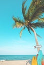 Vintage surf board with palm tree on tropical beach in summer. Royalty Free Stock Photo