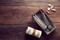 Vintage syringes, cocaine, pills and rolled dollar bills on wooden table Royalty Free Stock Photo