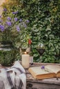Vintage table with composition of wildflowers in vase, a glass of wine and a candle in a pot Royalty Free Stock Photo