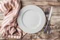 Vintage Table setting with napkin, fork, knife and plate on old rustic wooden table Royalty Free Stock Photo