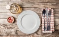 Vintage Table setting with napkin, fork, knife and plate on old rustic wooden table Royalty Free Stock Photo